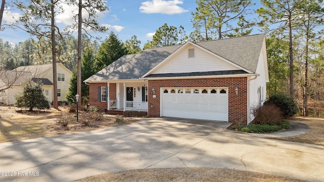 view of front of house featuring a garage, driveway, brick siding, and covered porch