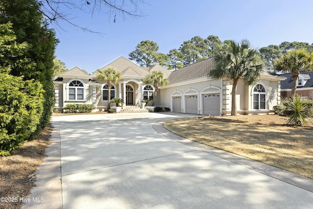 view of front of property with driveway, a garage, and stucco siding