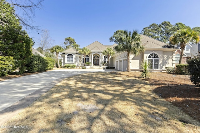 view of front of home featuring concrete driveway, an attached garage, and stucco siding