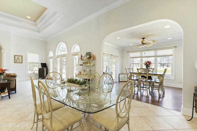 dining room with arched walkways, ornamental molding, and light tile patterned flooring