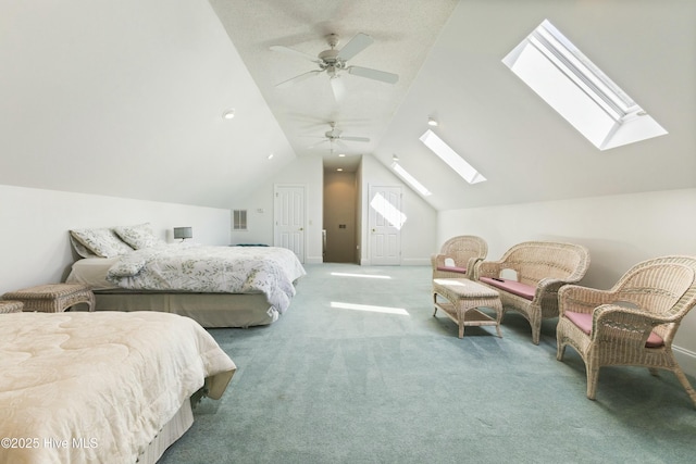 bedroom with ceiling fan, lofted ceiling with skylight, and carpet