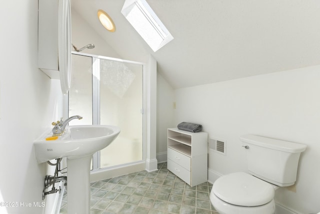 bathroom featuring vaulted ceiling with skylight, visible vents, baseboards, toilet, and a shower stall