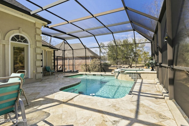 view of pool featuring glass enclosure, a pool with connected hot tub, and a patio area