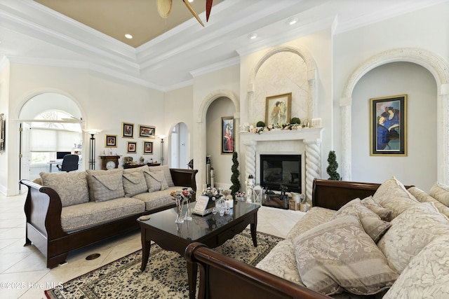 living room featuring light tile patterned floors, a tile fireplace, recessed lighting, ornamental molding, and a raised ceiling