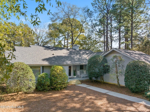 single story home featuring a porch and roof with shingles