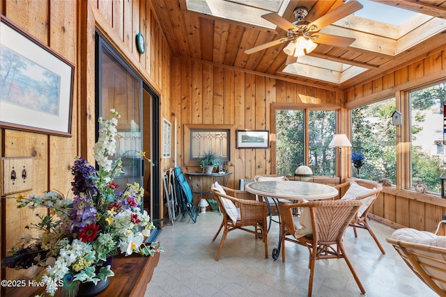 sunroom featuring wooden ceiling, vaulted ceiling with skylight, and ceiling fan