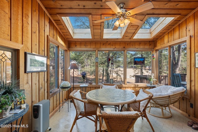 sunroom / solarium featuring vaulted ceiling with skylight, plenty of natural light, and radiator