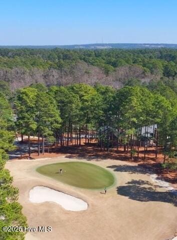 surrounding community with a forest view and view of golf course