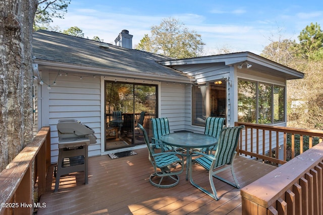 wooden terrace featuring outdoor dining area and grilling area