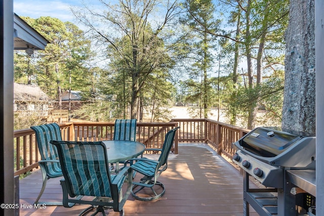 wooden terrace featuring outdoor dining space and a grill