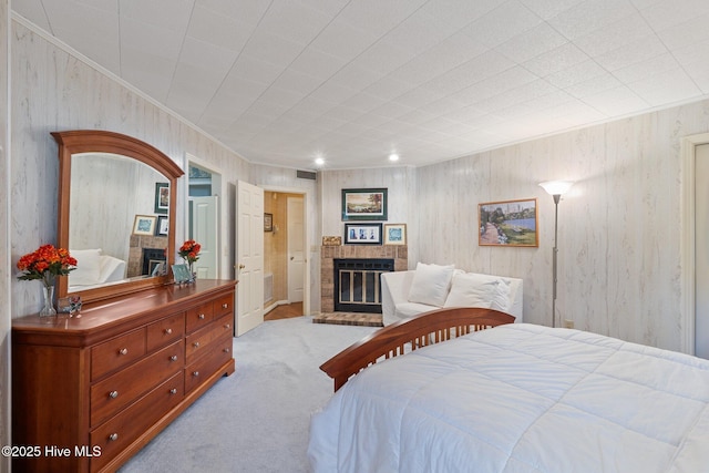 bedroom with a brick fireplace, ornamental molding, and light colored carpet