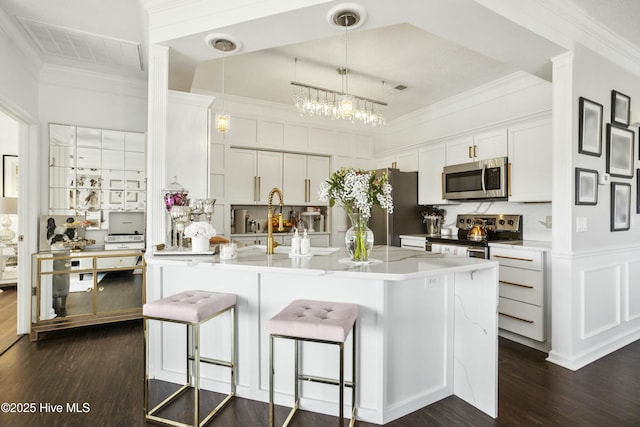 kitchen featuring dark wood-style floors, appliances with stainless steel finishes, white cabinets, and crown molding