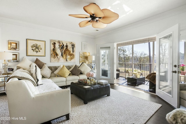 living area with ceiling fan, ornamental molding, and wood finished floors