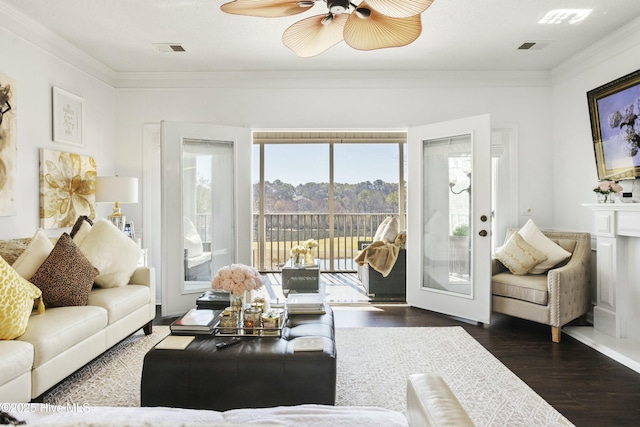 living area with visible vents, ornamental molding, ceiling fan, and wood finished floors