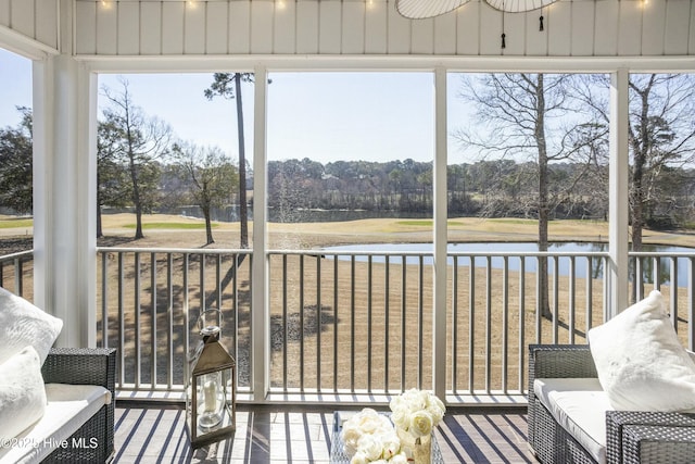 sunroom featuring a water view