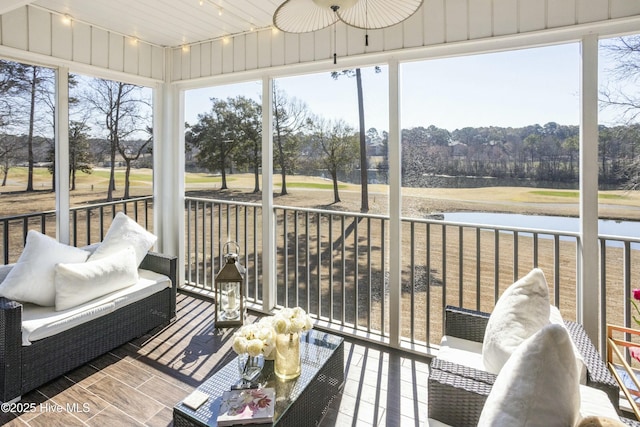 sunroom / solarium with a wealth of natural light, a water view, and rail lighting