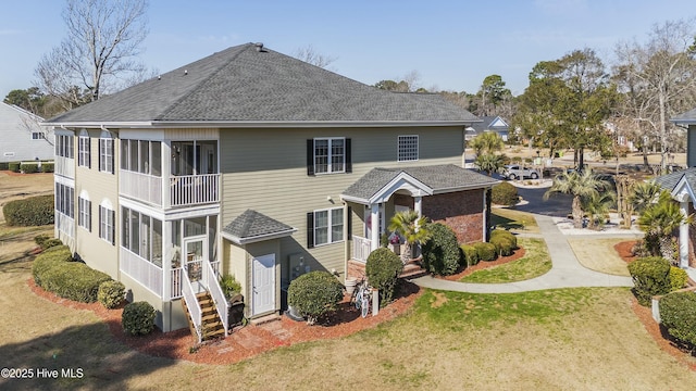 view of front of property with a shingled roof and a front lawn