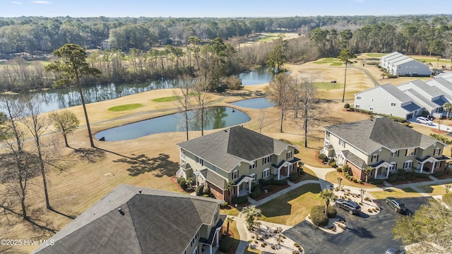 birds eye view of property with a water view and a wooded view