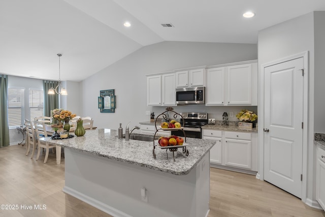 kitchen featuring white cabinets, visible vents, stainless steel appliances, and a sink