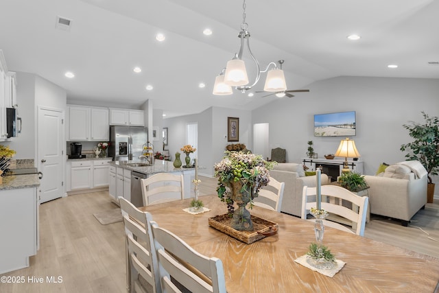 dining room with lofted ceiling, visible vents, light wood finished floors, and recessed lighting