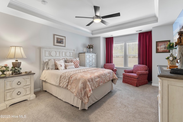 bedroom with light carpet, visible vents, a tray ceiling, and ornamental molding