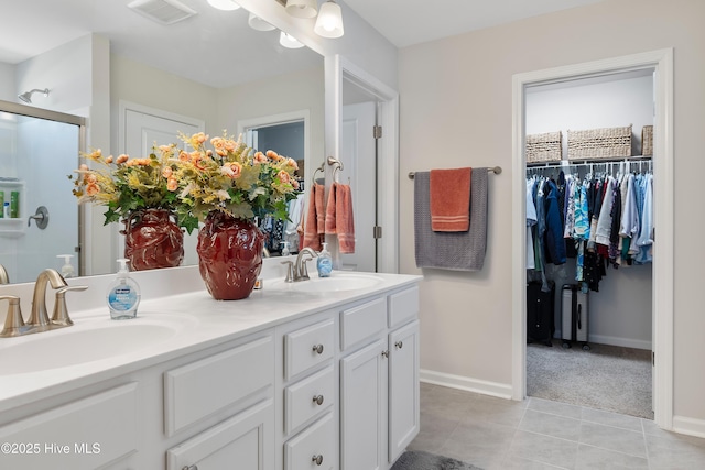 bathroom featuring a stall shower, tile patterned flooring, visible vents, and a sink