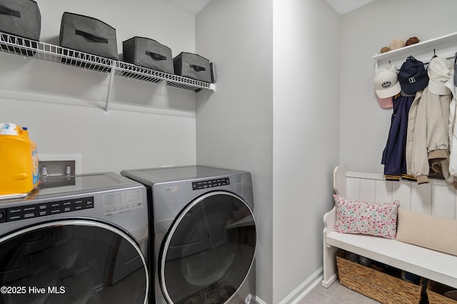 laundry room with laundry area, baseboards, washing machine and clothes dryer, and tile patterned floors