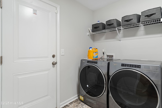 clothes washing area featuring laundry area, baseboards, and separate washer and dryer