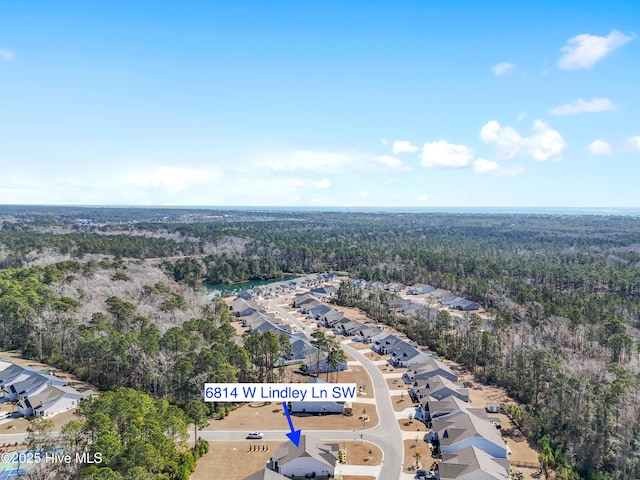 birds eye view of property featuring a residential view and a wooded view