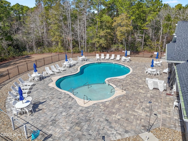 pool with a patio area and fence