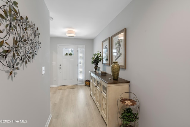 foyer with light wood-style floors and baseboards