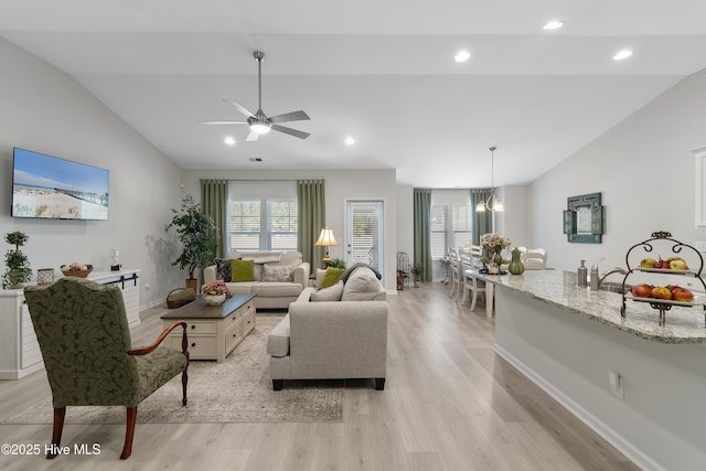 living area featuring lofted ceiling, recessed lighting, visible vents, baseboards, and light wood-style floors