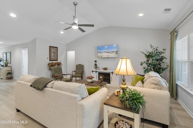 living room with recessed lighting, visible vents, vaulted ceiling, and light wood finished floors