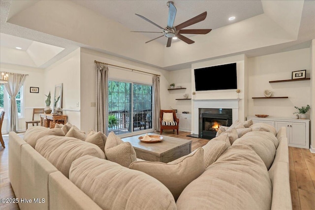 122 Smathers Dr, West End, NC 27376 - living area featuring a tray ceiling, light wood-style floors, ceiling fan, a glass covered fireplace, and recessed lighting