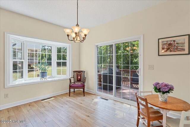 122 Smathers Dr, West End, NC 27376 - sitting room with a chandelier, baseboards, light wood-style floors, and a textured ceiling