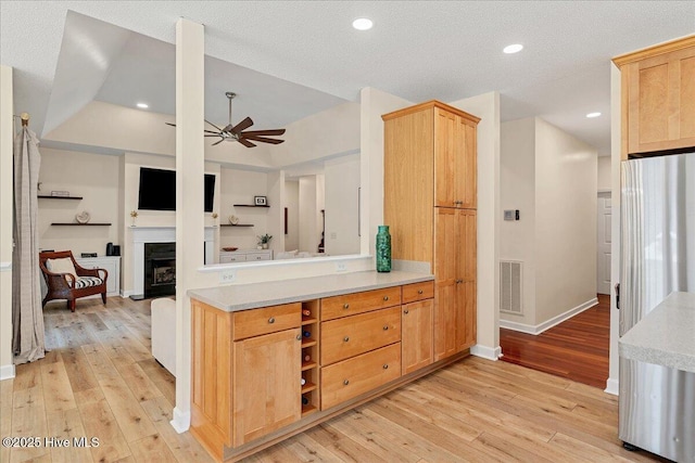 122 Smathers Dr, West End, NC 27376 - kitchen with ceiling fan, light wood-style flooring, light countertops, light brown cabinetry, and baseboards
