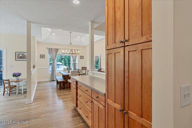 122 Smathers Dr, West End, NC 27376 - kitchen with a chandelier, light wood-type flooring, light countertops, a textured ceiling, and hanging light fixtures