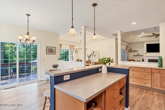 122 Smathers Dr, West End, NC 27376 - kitchen with a chandelier, light wood-style floors, open floor plan, a textured ceiling, and light countertops