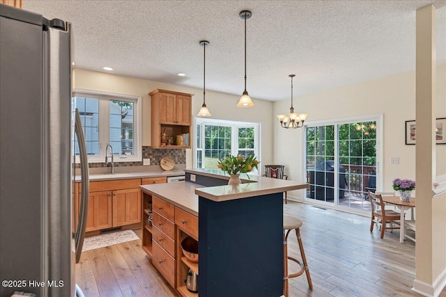 122 Smathers Dr, West End, NC 27376 - kitchen featuring freestanding refrigerator, open shelves, a sink, a textured ceiling, and a breakfast bar area