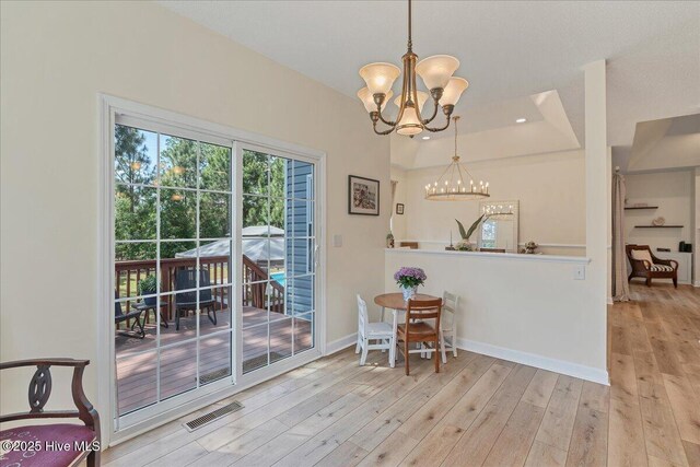 122 Smathers Dr, West End, NC 27376 - dining area with a chandelier, wood finished floors, baseboards, and a raised ceiling