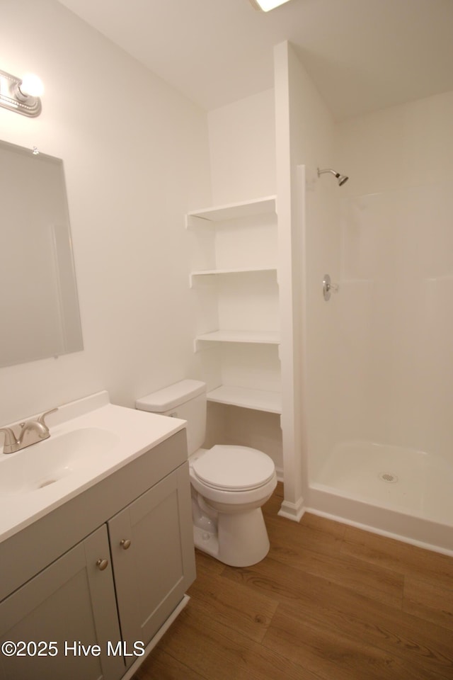 full bath with wood finished floors, vanity, toilet, and walk in shower