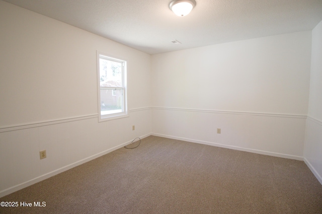 empty room featuring carpet and baseboards