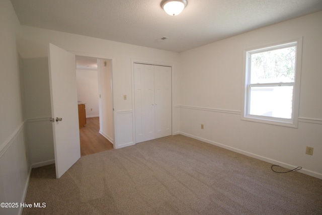 unfurnished bedroom featuring carpet and a closet