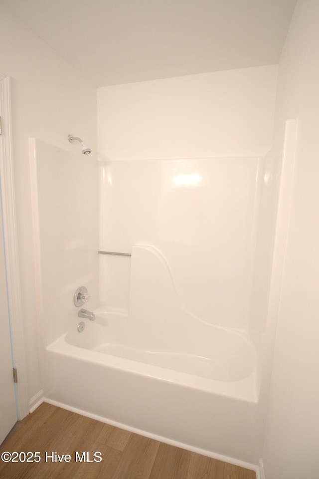 bathroom featuring tub / shower combination and wood finished floors