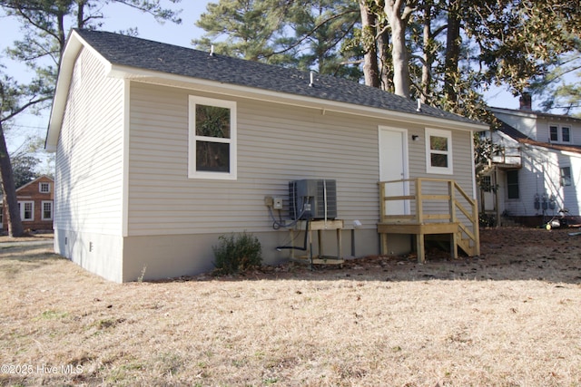 rear view of house with a shingled roof