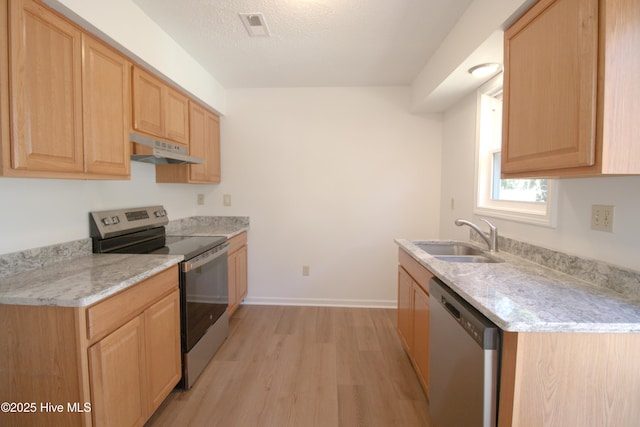 kitchen with under cabinet range hood, stainless steel appliances, a sink, visible vents, and light brown cabinetry