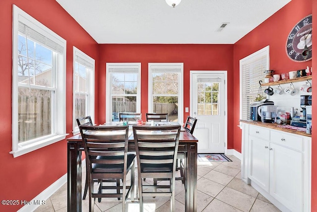 dining space featuring visible vents, plenty of natural light, baseboards, and light tile patterned floors