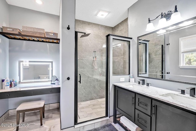 full bath with a stall shower, a sink, and double vanity