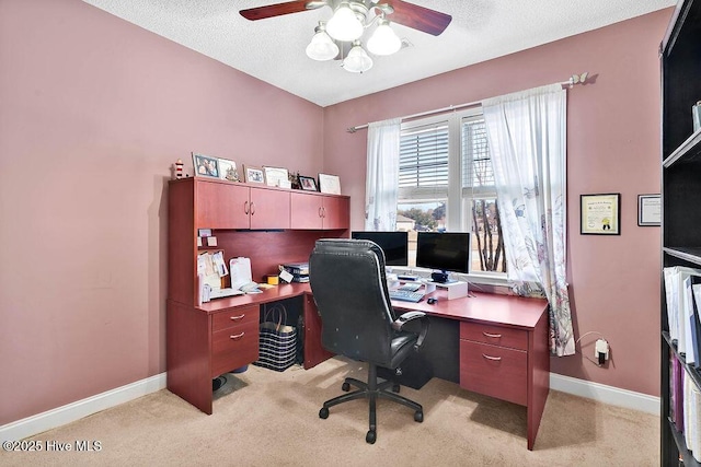 office space with light carpet, ceiling fan, a textured ceiling, and baseboards