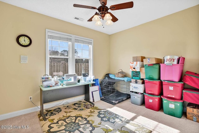 interior space featuring a ceiling fan, light colored carpet, visible vents, and baseboards